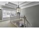 Elegant hallway with staircase featuring a decorative light fixture and natural light at 3433 Pinemont Dr, Douglasville, GA 30135