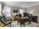 This home office boasts a traditional wood desk, ample natural light, and comfortable seating at 3433 Pinemont Dr, Douglasville, GA 30135