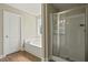 Bathroom showcasing a shower with glass doors, soaking tub, and wood-look flooring at 1300 Snapping Shoals Rd, Mcdonough, GA 30252