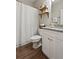 Bathroom showcasing a single sink granite vanity, wood-look flooring, shelves, and a shower at 1300 Snapping Shoals Rd, Mcdonough, GA 30252