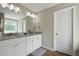 Bathroom with double sink granite vanity, white cabinets, wood-look flooring, and a white door at 1300 Snapping Shoals Rd, Mcdonough, GA 30252