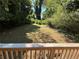 Spacious backyard with lush greenery visible from wooden deck with wooden railings at 1766 Venetian Sw Dr, Atlanta, GA 30311