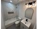 Bright bathroom featuring a tub with marble tile surround and stylish vanity with black faucet at 1766 Venetian Sw Dr, Atlanta, GA 30311