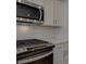 Modern kitchen with stainless steel microwave, range, white cabinets and subway tile backsplash at 3336 Cranston Ln, Kennesaw, GA 30144