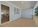 Relaxing covered patio area with wood flooring and a view of the kitchen island through a large sliding glass door at 3336 Cranston Ln, Kennesaw, GA 30144