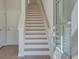 Bright staircase with hardwood steps and white risers, complemented by a wood handrail and natural light at 3336 Cranston Ln, Kennesaw, GA 30144