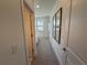 Hallway with carpet and artwork leads to a bedroom with bright, natural light from the window at 3987 Allegretto Cir # 250, Atlanta, GA 30339