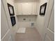 Neat laundry room with white cabinets, decor, and tile flooring at 3987 Allegretto Cir # 250, Atlanta, GA 30339