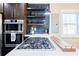 Close-up of kitchen with stainless steel gas cooktop and unique tile backsplash at 727 Cool Hollow Dr, Decatur, GA 30033