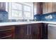 Close up on a sink, window, and backsplash in a kitchen with rich wood cabinetry and stainless steel appliances at 727 Cool Hollow Dr, Decatur, GA 30033