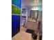 Vibrant bathroom with unique blue accents, a storage tower, and decorative mirror at 123 Spring St, Stockbridge, GA 30281