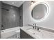 Bathroom featuring modern vanity, lighted mirror, and tiled shower-tub combo at 1653 Wayland Ne Cir, Brookhaven, GA 30319