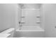 White tub-shower combination with built-in shelving for storage and convenience at 3624 Silvery Way, Powder Springs, GA 30127