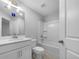 Clean white bathroom featuring tiled floors, vanity, and tub-shower combo at 3624 Silvery Way, Powder Springs, GA 30127