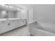 Bright bathroom features a large mirror, double sink vanity, and soaking tub at 3624 Silvery Way, Powder Springs, GA 30127