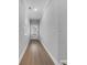 A minimalist long hallway with hardwood floors and neutral colored walls at 3624 Silvery Way, Powder Springs, GA 30127