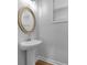 Charming powder room with a pedestal sink and round decorative mirror at 3624 Silvery Way, Powder Springs, GA 30127