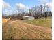 Wide shot of large lot with a fenced backyard and metal building at 3696 Lower Burris Rd, Canton, GA 30114