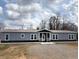 New construction gray home featuring a covered entryway and a well-manicured lawn, perfect for modern living at 3696 Lower Burris Rd, Canton, GA 30114