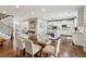 Dining room features hardwood floors, staircase, and view of a modern kitchen at 5365 Vendelay Ln, Cumming, GA 30040