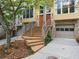 Townhome exterior showcasing a brick facade, front-entry garages, and manicured landscaping at 1323 Peachtree Ne Vw, Atlanta, GA 30319