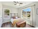 This bright bedroom features hardwood floors, a ceiling fan, and large windows at 1521 Dianne Se Ct, Atlanta, GA 30316