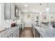 Bright kitchen featuring stainless appliances, marble counters, an island, and wood-look floors at 1521 Dianne Se Ct, Atlanta, GA 30316