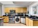 Modern kitchen featuring black countertops, stainless steel appliances, and maple cabinets at 300 Peachtree St # 23-A, Atlanta, GA 30308