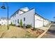 A modern townhome featuring white siding, dark trim, and well-maintained landscaping and a neighborhood street view at 83 Arnold Poplar Ln, Auburn, GA 30011