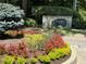 Stone monument sign for Rivermont The Village surrounded by vibrant, colorful flowers and greenery at 406 Hawkstone Way, Alpharetta, GA 30022