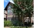 Charming two-story townhouse with lush landscaping, including a large, flowering crepe myrtle tree at 406 Hawkstone Way, Alpharetta, GA 30022
