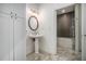 Elegant bathroom features a pedestal sink, oval mirror, and tiled floor at 850 Piedmont Ne Ave # 1302, Atlanta, GA 30308