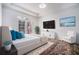 Bedroom with French doors, hardwood floors, TV, beach scene art and a comfy chair at 850 Piedmont Ne Ave # 1302, Atlanta, GA 30308