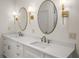 Bathroom featuring double vanity with marble countertops, modern fixtures, and oval decorative mirrors at 993 Northrope Ne Dr, Atlanta, GA 30324