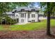 Backyard with white painted brick, covered patio, large windows and doors and lush green lawn at 2023 Stoneleigh Dr, Stone Mountain, GA 30087