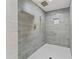 Modern walk-in shower with gray wood-look tile walls, hexagon floor, gold fixtures, and a rainfall shower head at 2023 Stoneleigh Dr, Stone Mountain, GA 30087