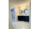 A modern bathroom features dual vanities with elegant round mirrors and a walk-in shower at 3078 Parc Lorraine, Lithonia, GA 30038