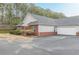 Exterior view of the property featuring a side entry two-car garage and manicured landscaping at 4809 Shae Ct, Powder Springs, GA 30127