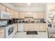 Well-lit kitchen with light wood cabinets, granite countertops, and white appliances at 4809 Shae Ct, Powder Springs, GA 30127