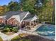 Aerial view of a community pool area featuring a covered patio, lounge chairs, and lush surrounding greenery at 4809 Shae Ct, Powder Springs, GA 30127