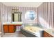 Bathroom with a large tub, vanity with sink, and striped walls at 4852 Gold Nugget Way, Sugar Hill, GA 30518
