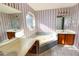 Bathroom with jacuzzi tub, dual vanities and striped wall paper at 4852 Gold Nugget Way, Sugar Hill, GA 30518