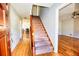 Inviting foyer featuring hardwood floors and a carpeted staircase leading to the upper level at 4852 Gold Nugget Way, Sugar Hill, GA 30518