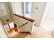 Carpeted stairway with wooden railing, leading to a hallway, offering a glimpse of the home's interior at 4852 Gold Nugget Way, Sugar Hill, GA 30518