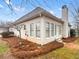 Backyard view featuring mature trees, meticulous pine straw beds, and exterior of the home at 9135 Woodhaven Way, Mcdonough, GA 30253