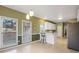 Eat-in kitchen boasts white cabinetry, a breakfast bar, stainless refrigerator, and light-filled windows overlooking the yard at 9135 Woodhaven Way, Mcdonough, GA 30253
