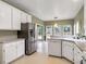 Kitchen boasts stainless steel refrigerator, white cabinets, dishwasher, and plenty of natural light at 9135 Woodhaven Way, Mcdonough, GA 30253