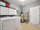 Functional laundry room featuring a washer, dryer, storage cabinets and wire rack shelving at 9135 Woodhaven Way, Mcdonough, GA 30253