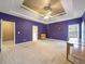 Spacious main bedroom features a tray ceiling with fan and neutral carpet at 9135 Woodhaven Way, Mcdonough, GA 30253