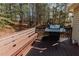 Wooden deck with a grill and bench seating, creating a perfect spot for outdoor cooking and relaxation at 31 Wyngate Ct, Dallas, GA 30157